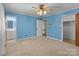 Bright bedroom with light blue walls, neutral carpet, and ceiling fan with light fixture at 407 Pinecroft Ln, Spencer, NC 28159