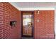 Close-up of the front entrance featuring a decorative glass door, brick facade, and stylish mailbox at 407 Pinecroft Ln, Spencer, NC 28159