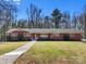 Traditional brick home featuring a well-maintained lawn, mature trees, and shrubbery at 407 Pinecroft Ln, Spencer, NC 28159
