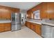 Functional kitchen with wooden cabinets, light countertops, stainless steel refrigerator, and modern appliances at 407 Pinecroft Ln, Spencer, NC 28159