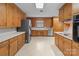 Functional kitchen with wooden cabinets, light countertops, stainless steel refrigerator, and modern appliances at 407 Pinecroft Ln, Spencer, NC 28159