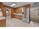 Traditional kitchen features wood cabinets, tile floor, and stainless steel refrigerator at 407 Pinecroft Ln, Spencer, NC 28159