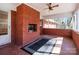 Enclosed sunroom features brick fireplace, ceiling fan and tiled flooring at 407 Pinecroft Ln, Spencer, NC 28159