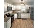 Functional kitchen featuring white cabinets, stainless steel appliances, and wood-look flooring at 409 Fourth St, York, SC 29745