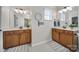 Well-lit bathroom with double vanities, white countertops and two decorative mirrors at 44421 Oriole Dr # 203, Indian Land, SC 29707