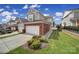 Home showcasing brick exterior, two-car garage, and landscaping under a blue sky with some clouds at 44421 Oriole Dr # 203, Indian Land, SC 29707