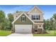 Charming two-story home featuring a two-car garage, stone accents, and manicured lawn at 4465 Dusty Orchard Rd, Kannapolis, NC 28081