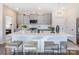 Contemporary kitchen with an island featuring barstool seating, gray cabinets, modern appliances, and white subway tile backsplash at 4465 Dusty Orchard Rd, Kannapolis, NC 28081