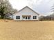 The back exterior has white siding, a grassy yard, and windows for plenty of natural light at 5609 Morgan Mill Rd, Monroe, NC 28110