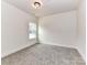 A cozy bedroom with neutral carpet, modern lighting, and a window for natural light at 5609 Morgan Mill Rd, Monroe, NC 28110