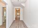 Hallway with light-colored walls and wood-look flooring, leading to bedrooms and other living spaces at 5609 Morgan Mill Rd, Monroe, NC 28110