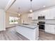 Open kitchen with stainless appliances, large island, pendant lights, and view to light-filled dining area at 5609 Morgan Mill Rd, Monroe, NC 28110