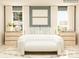 Bright bedroom with two windows, decorative pillows, and natural wood dressers flanking the bed at 5710 Olive Beach Rd, Kannapolis, NC 28081