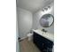 Bathroom featuring a modern vanity with a dark blue cabinet and round mirror at 5949 Flat Creek Rd, Kershaw, SC 29067