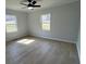 This bedroom features wood-look flooring, a ceiling fan, and two windows at 5949 Flat Creek Rd, Kershaw, SC 29067