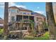Large backyard featuring a covered porch, patio, stone fireplace, and lush landscaping at 653 Buckleigh Nw Ct, Concord, NC 28027