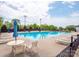 Relaxing community pool area with lounge chairs and umbrellas under a bright, partly cloudy sky at 653 Buckleigh Nw Ct, Concord, NC 28027