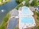 Aerial view of a pristine community pool with ample seating and a clubhouse, adjacent to a scenic lake at 653 Buckleigh Nw Ct, Concord, NC 28027