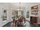 Inviting dining room with natural light, a modern chandelier, and views of the beautiful wooded backyard at 653 Buckleigh Nw Ct, Concord, NC 28027