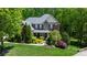 Charming two-story brick home featuring a well-manicured lawn and lush landscaping at 653 Buckleigh Nw Ct, Concord, NC 28027