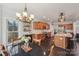 Gourmet kitchen with wood cabinets, a large island, and modern lighting fixtures over the dining table at 653 Buckleigh Nw Ct, Concord, NC 28027
