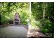 Beautiful stone patio with an outdoor fireplace and landscaped surroundings perfect for entertaining at 653 Buckleigh Nw Ct, Concord, NC 28027