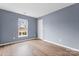 Well-lit bedroom features a window with bright natural light, neutral-colored walls, and wood-look flooring at 7047 Whittingham Dr, Indian Land, SC 29707