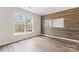 Bedroom featuring wood-look flooring, accent wall, and large window to bring in natural light at 7047 Whittingham Dr, Indian Land, SC 29707