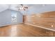 Upstairs bedroom featuring hardwood floors, modern accent wall, ceiling fan and natural light at 7047 Whittingham Dr, Indian Land, SC 29707