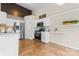 Stylish kitchen featuring stainless steel appliances, white cabinets, light backsplash, and beautiful wood flooring at 7047 Whittingham Dr, Indian Land, SC 29707