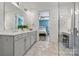 Bright bathroom features double sink vanity with stone countertops, tile floors and a large mirror at 7118 Overjoyed Xing, Charlotte, NC 28215