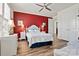 Comfortable bedroom featuring a red accent wall, ceiling fan, and hardwood floors at 7118 Overjoyed Xing, Charlotte, NC 28215