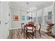 Cozy dining room featuring natural light from three windows, hardwood floors, and a classic chandelier at 7118 Overjoyed Xing, Charlotte, NC 28215