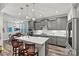 Bright, open kitchen with a large kitchen island, pendant lighting, stainless steel appliances, and gray cabinets at 7118 Overjoyed Xing, Charlotte, NC 28215