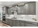 Stylish kitchen with gray cabinets, white backsplash, stainless steel appliances, and modern lighting at 7118 Overjoyed Xing, Charlotte, NC 28215