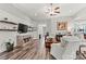 Comfortable living room with hardwood floors, ceiling fan, entertainment center, and light gray walls at 7118 Overjoyed Xing, Charlotte, NC 28215