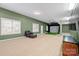 Finished basement features a golf simulator, seating, and carpeted floors at 722 Fairway Point Dr, Fort Mill, SC 29708