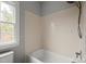 Bathroom features a tub with a showerhead and view of a window at 722 Fairway Point Dr, Fort Mill, SC 29708