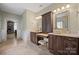 This bathroom boasts dual sinks with dark wood cabinetry, a vanity, and decorative lighting at 722 Fairway Point Dr, Fort Mill, SC 29708