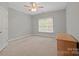Neutral bedroom with a ceiling fan, window and wooden drawers, inviting comfort at 722 Fairway Point Dr, Fort Mill, SC 29708