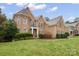 Traditional brick home with manicured lawn and detailed architectural features under a partly cloudy sky at 722 Fairway Point Dr, Fort Mill, SC 29708