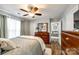 Bright bedroom featuring wood-look floors, neutral tones, ceiling fan, and an open doorway at 730 Shuttles Way, Fort Mill, SC 29715