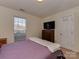 Cozy bedroom with neutral walls and a flat screen tv above a wooden dresser at 8527 Conner Ridge Ln, Charlotte, NC 28269
