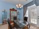 Elegant dining area with a glass-topped table, decorative display cabinets, and ample natural light from the door at 8527 Conner Ridge Ln, Charlotte, NC 28269
