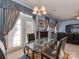 Dining area featuring a glass table, elegant curtains, and access to the outside, creating a refined and airy atmosphere at 8527 Conner Ridge Ln, Charlotte, NC 28269