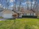 Cozy one-story house with a two-car garage, trimmed bushes, and a manicured lawn, set in a wooded area at 8527 Conner Ridge Ln, Charlotte, NC 28269