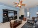 Bright living room featuring a ceiling fan, dark wood entertainment center, and comfortable seating, with blue walls at 8527 Conner Ridge Ln, Charlotte, NC 28269