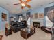 Comfortable living room with a fireplace, plush seating, and glass top tables, under a unique ceiling fan at 8527 Conner Ridge Ln, Charlotte, NC 28269
