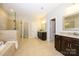 Modern bathroom features a soaking tub, glass-enclosed shower, and double vanity at 8941 Vickery Ln, Harrisburg, NC 28075