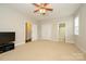 A large bonus room with multiple doors, a window, neutral paint, a ceiling fan, and carpet floors at 8941 Vickery Ln, Harrisburg, NC 28075